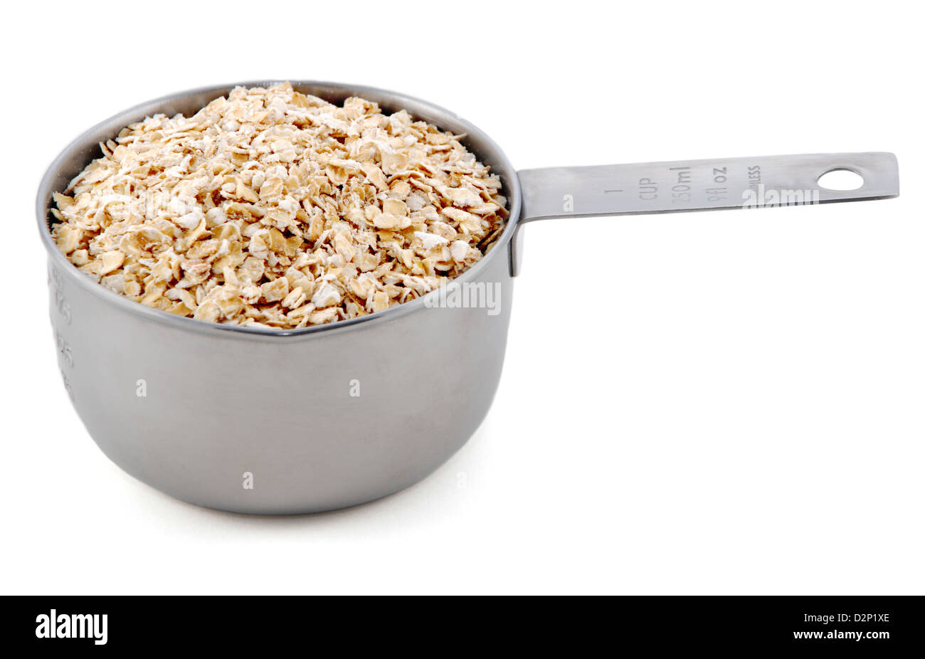 Haferflocken in eine amerikanische Metallpfanne Maßnahme, isoliert auf weißem Hintergrund dargestellt Stockfoto