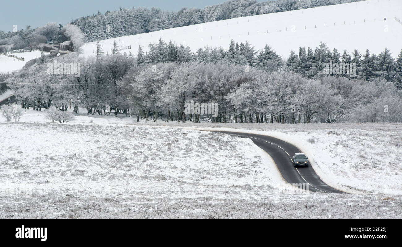 Ein Auto fährt entlang der A39 Somerset zwischen Porlock und Lynton in einer Winterlandschaft Schnee bereift, Exmoor Stockfoto