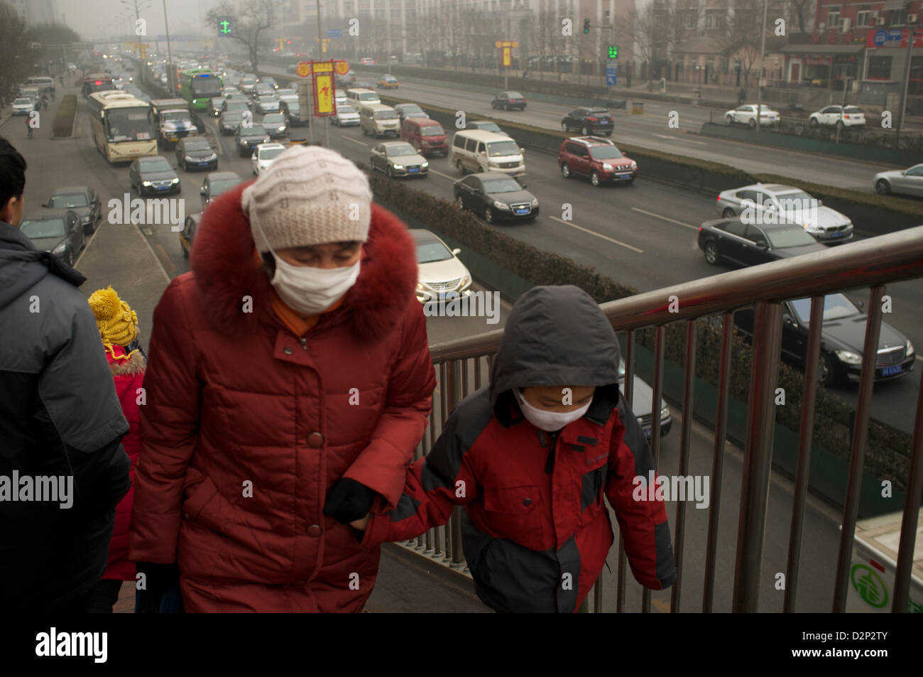 Fußgänger tragen Masken auf einer Überführung in dicker Nebel in Peking, China. Jan - 2013 Stockfoto