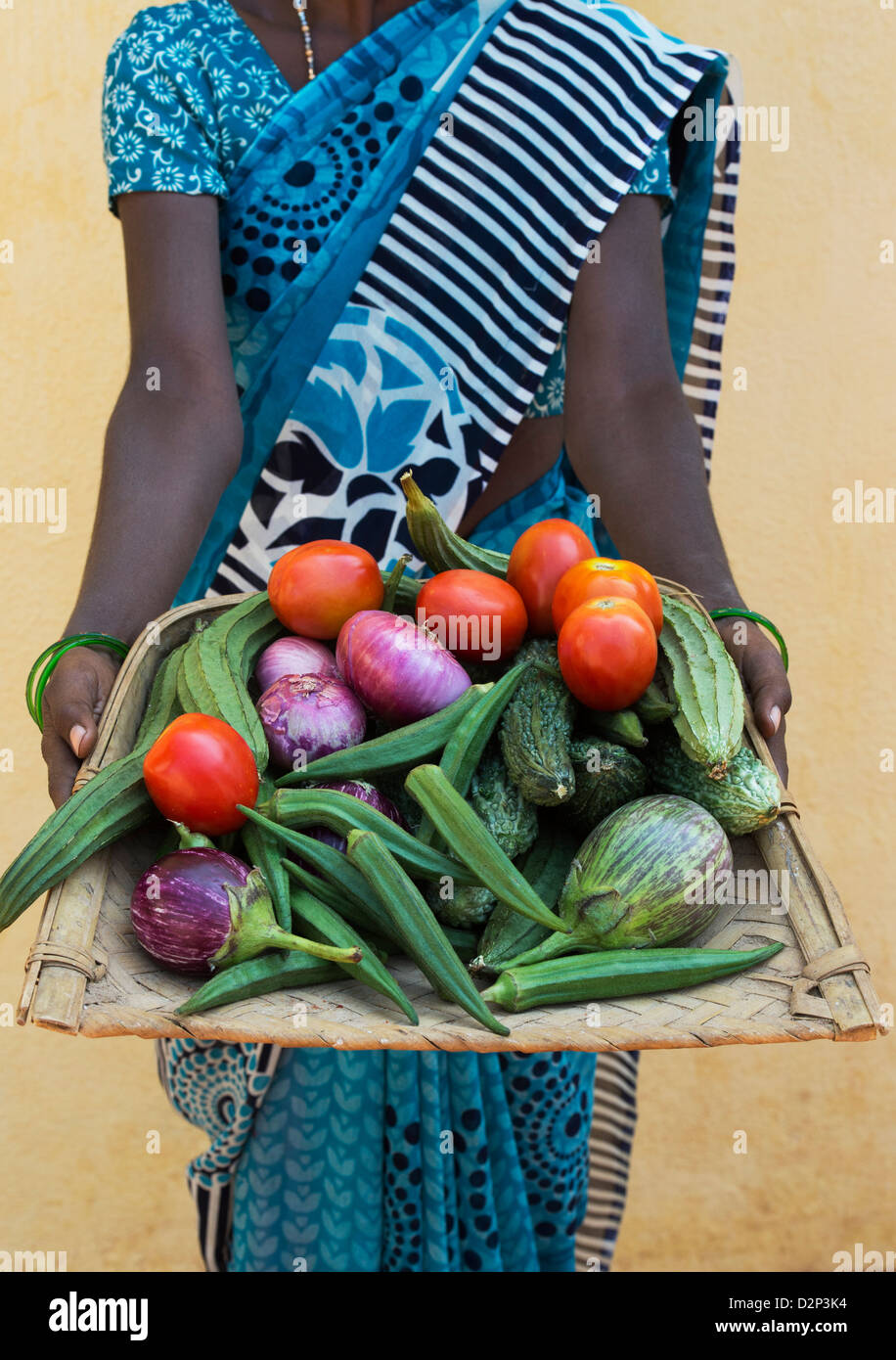 Indische Dorf Frau ein Tablett mit indischen Gemüse in ihren Händen hält. Andhra Pradesh, Indien Stockfoto