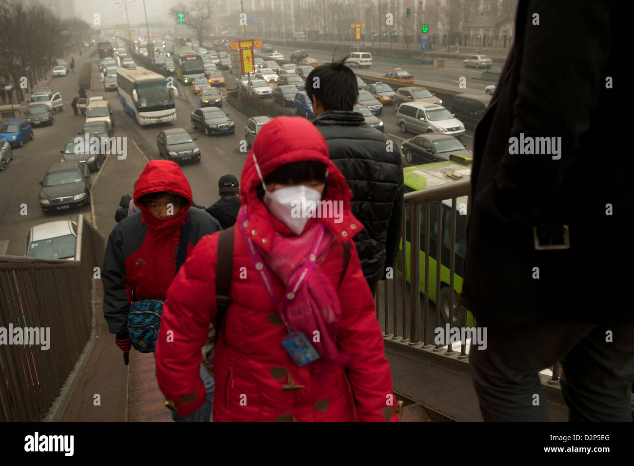Eine Mädchen trägt eine Maske vorbei an stark befahrenen in dicker Nebel in Peking, China. 30 - Jan 2013 Stockfoto