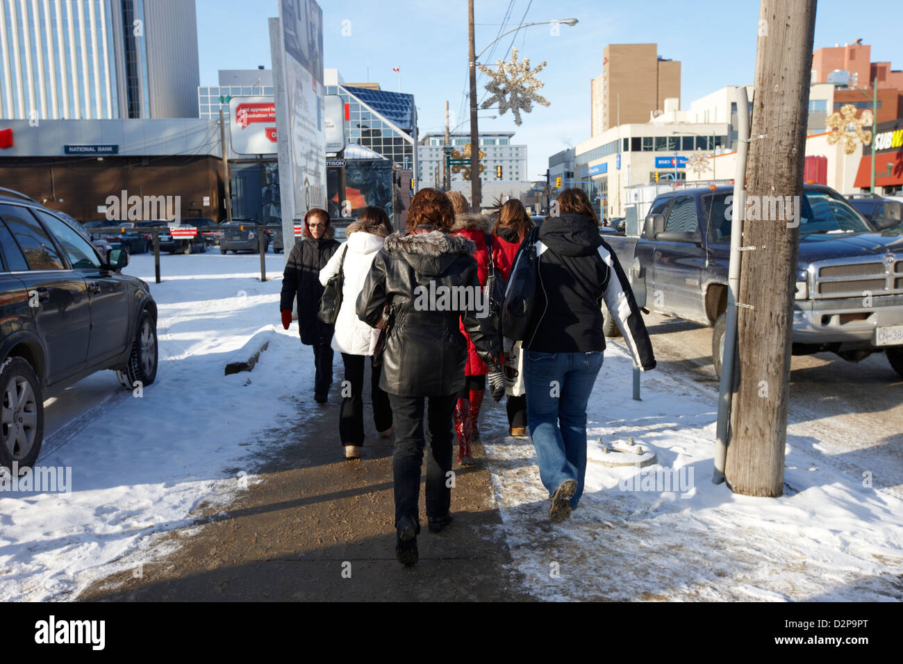 Frauen tragen Winterkleidung entlang kalter Schnee bedeckt Innenstadt Straße Saskatoon Saskatchewan Kanada Stockfoto