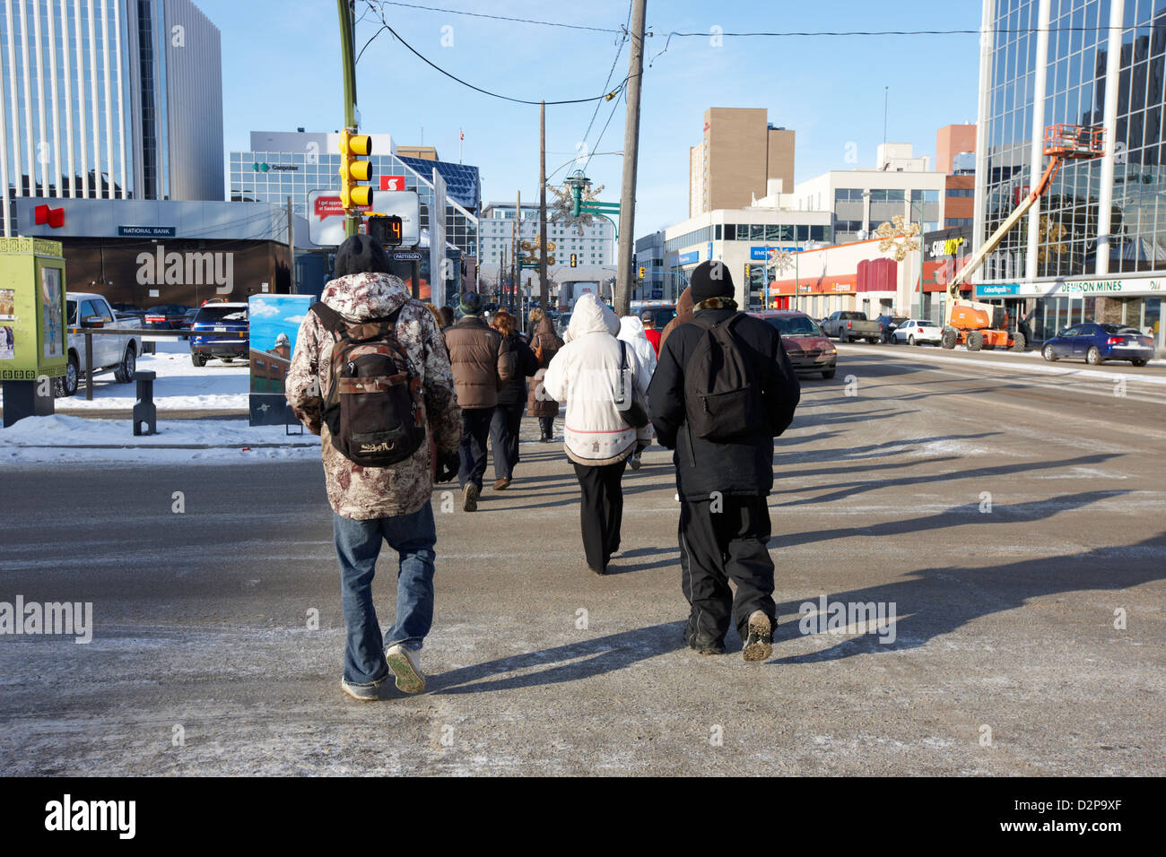 Menschen tragen Winterkleidung zu Fuß quer durch die Innenstadt, die Straße im Winter Saskatoon Saskatchewan Kanada Stockfoto