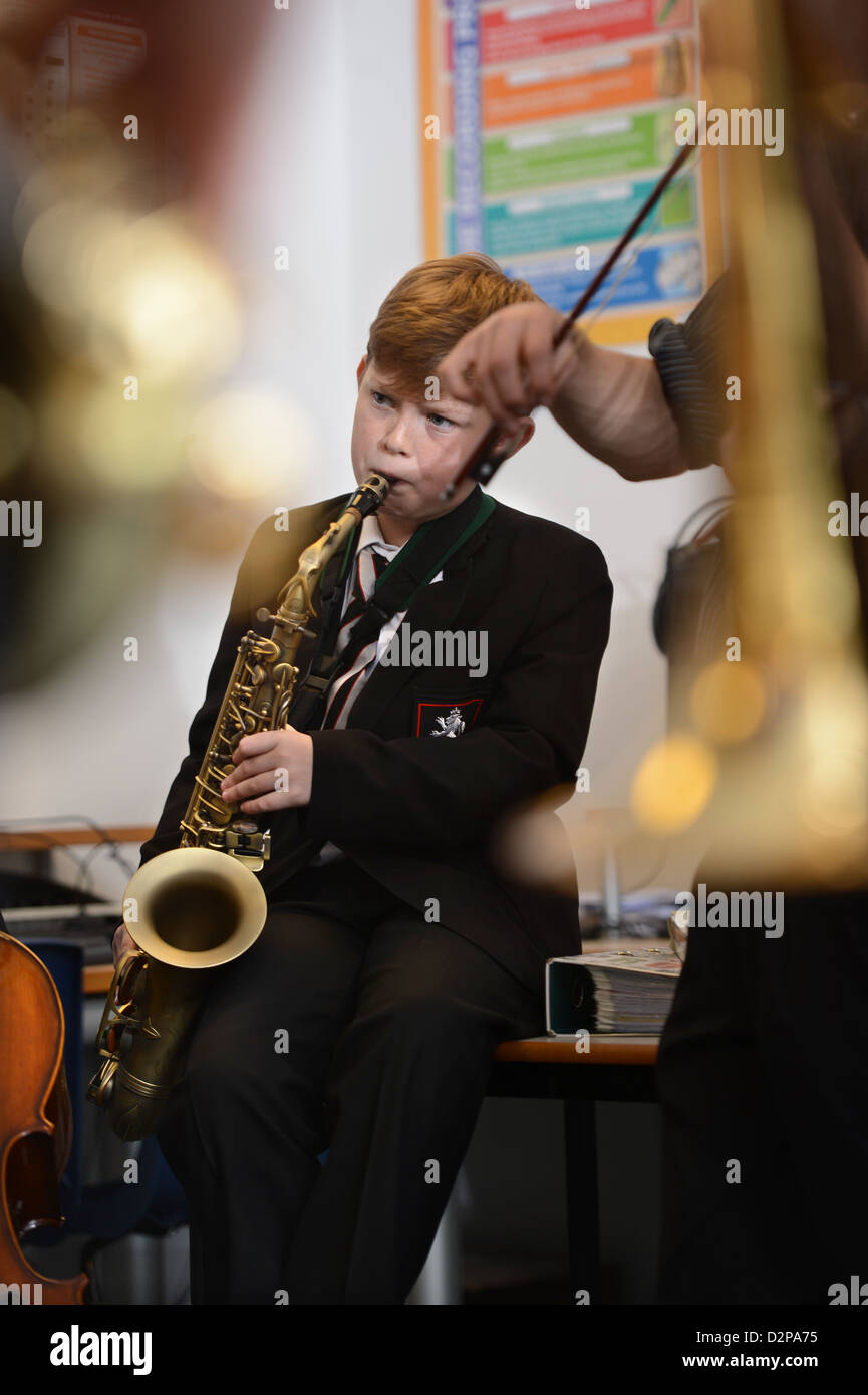 Ein Junge spielt ein Saxophon bei einer Bandprobe an Pasteten Grammar School in Cheltenham, Gloucestershire UK Stockfoto