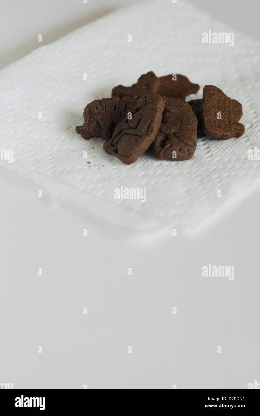 Tier geformt Schokoladenkekse auf weißem Papierserviette, vertikale Stockfoto