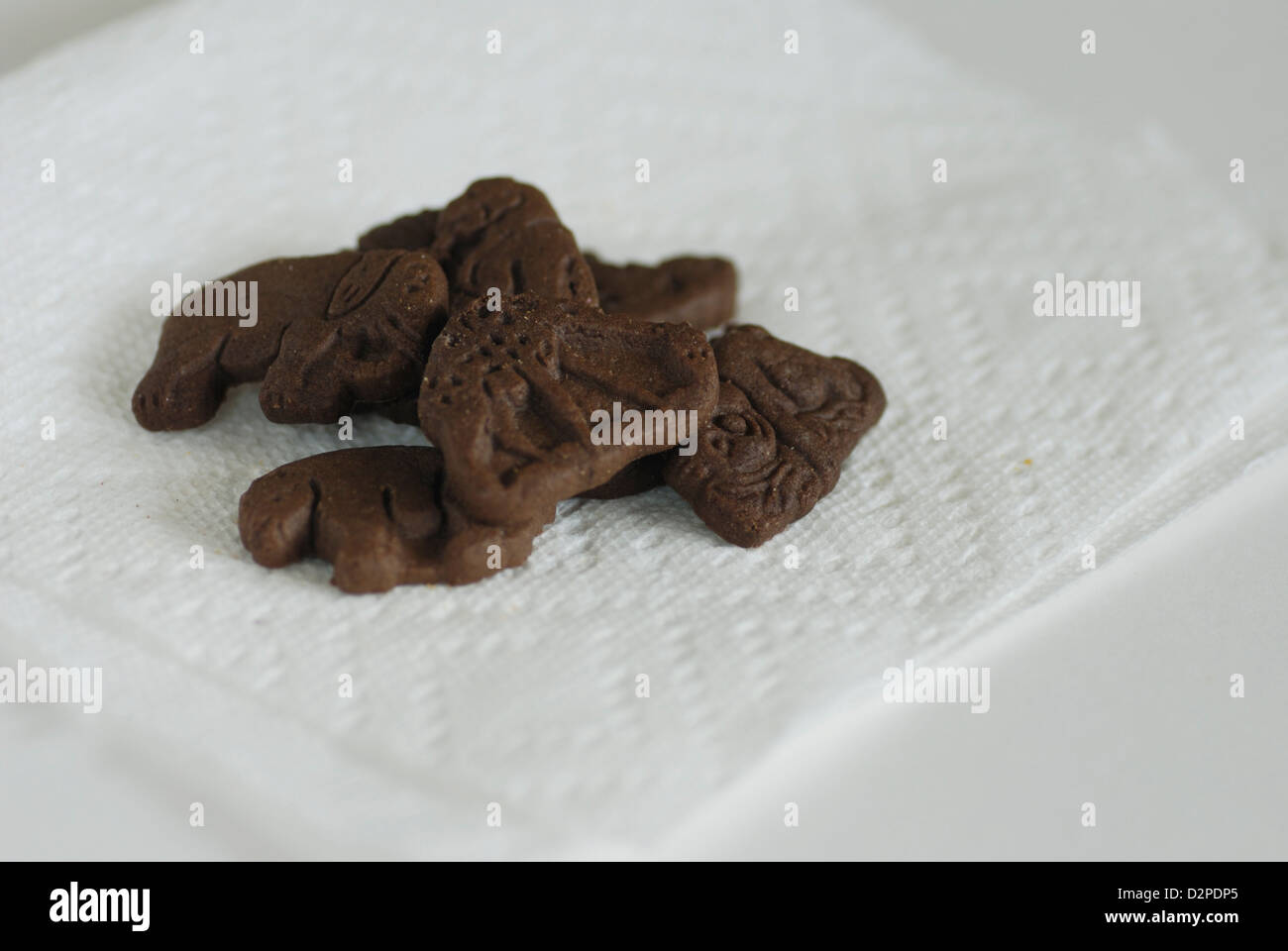 Tier geformt Schokoladenkekse auf weißem Papierserviette Stockfoto