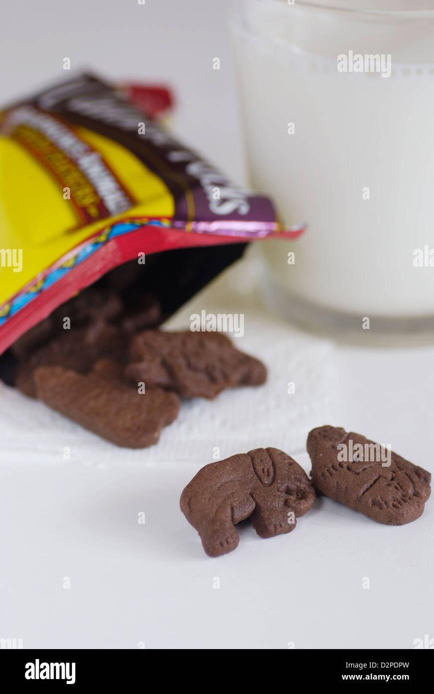 Schokolade Tier geformt, Cookies mit Glas Kuhmilch vertikal mit Elefanten und Gorillas Cookie aus Paket Stockfoto