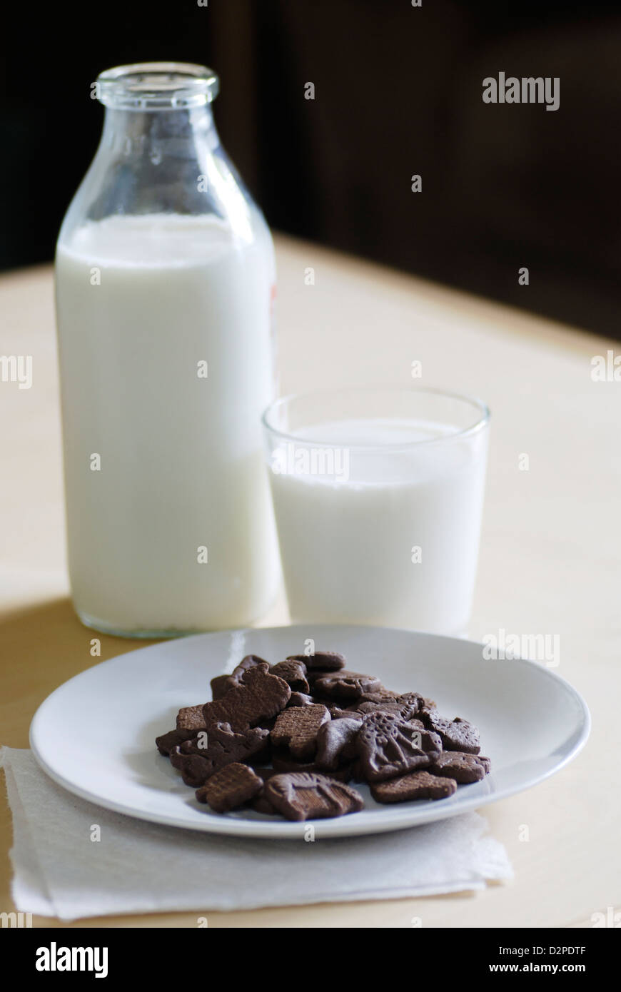 Schokolade Tier geformt Cookies mit Flasche und Glas Kuhmilch vertikale Stockfoto