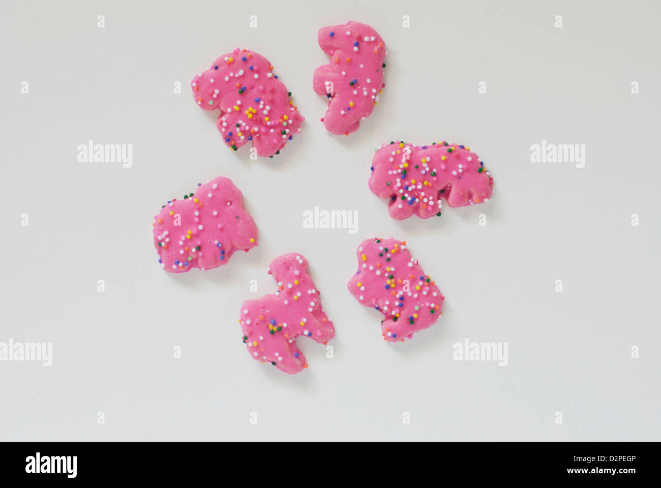 Rosa Frosted Tier Cookies mit Streuseln auf weißem Hintergrund Stockfoto