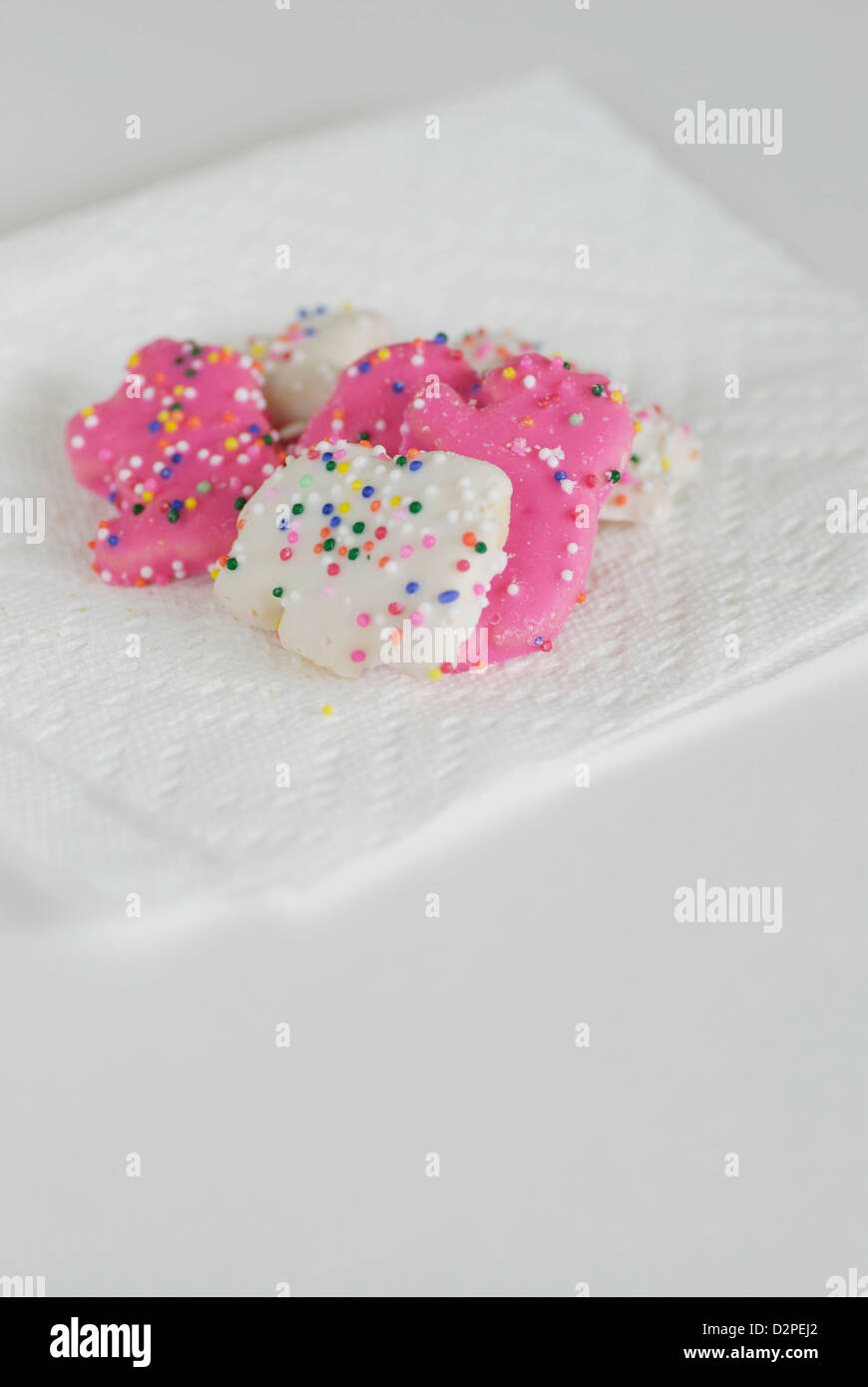 Rosa und weiß gefrostet Tier Cookies mit Streusel auf eine weiße Serviette Stockfoto