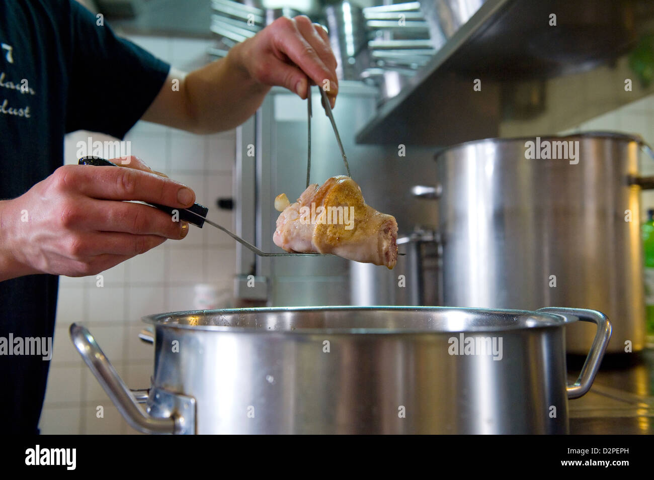 Berlin, Deutschland-Chef Marco Mueller während des Kochens von Eisbein Stockfoto