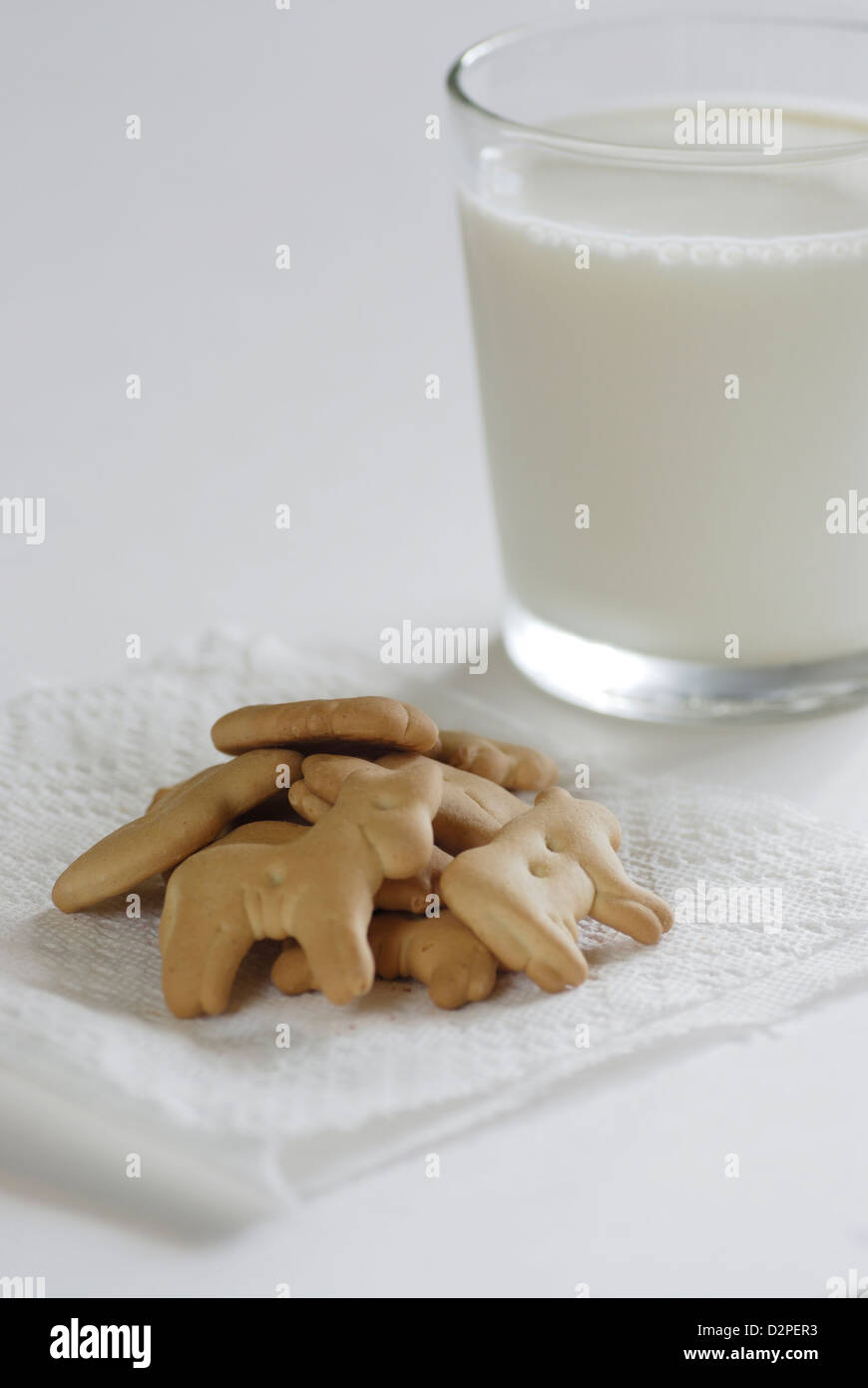 Animal Crackers auf weiße Serviette mit einem Glas Kuhmilch auf weißem Hintergrund Stockfoto