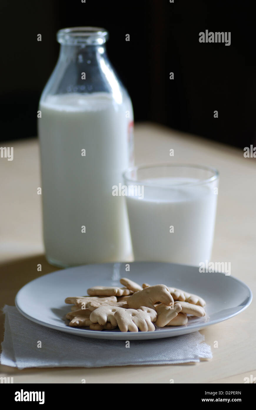 Animal Crackers auf weißen Teller mit Milchflasche und Glas Milch und Serviette Stockfoto