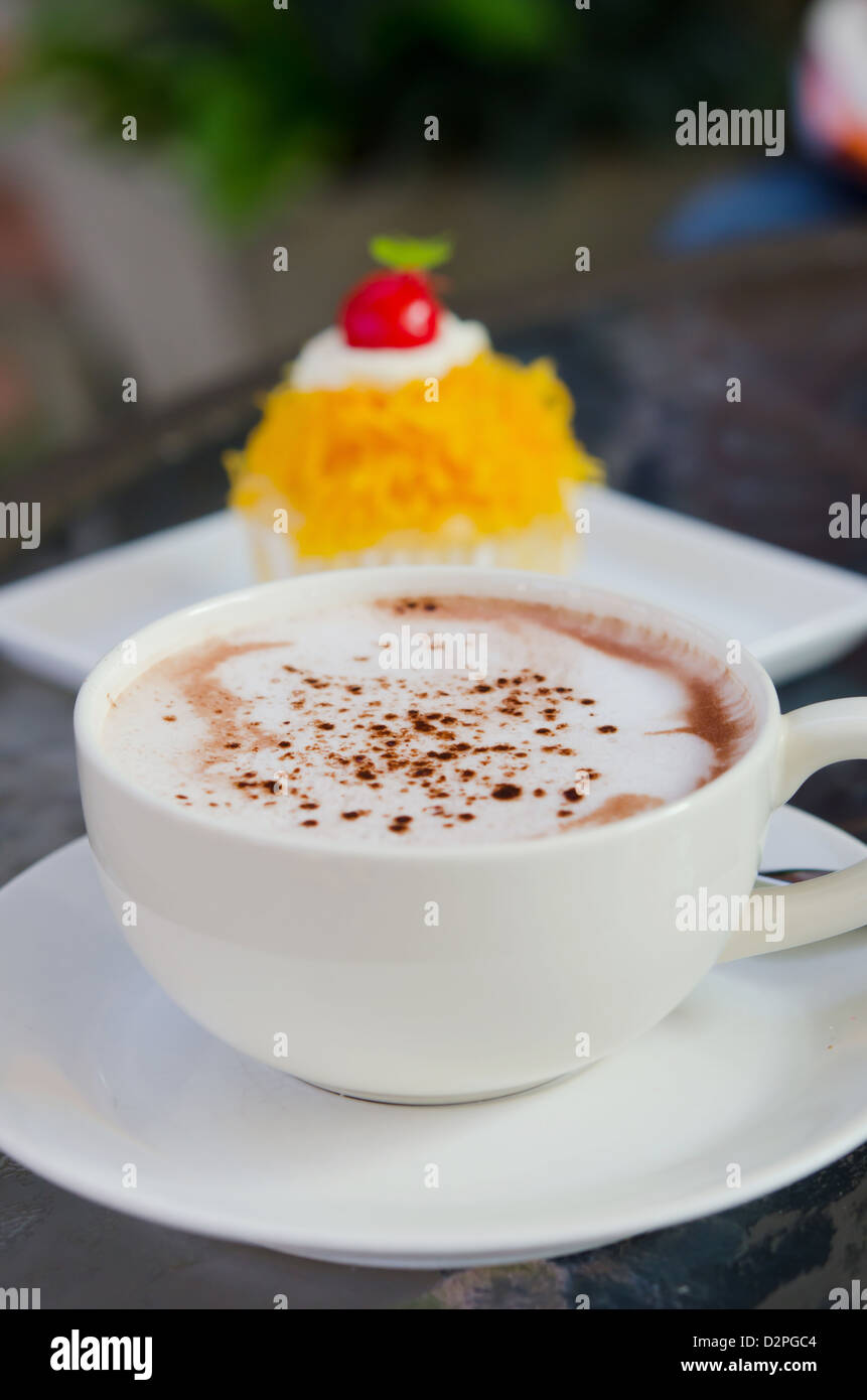 heißer Cappuccino Milchkaffee Tasse und süße Kuchen Stockfoto