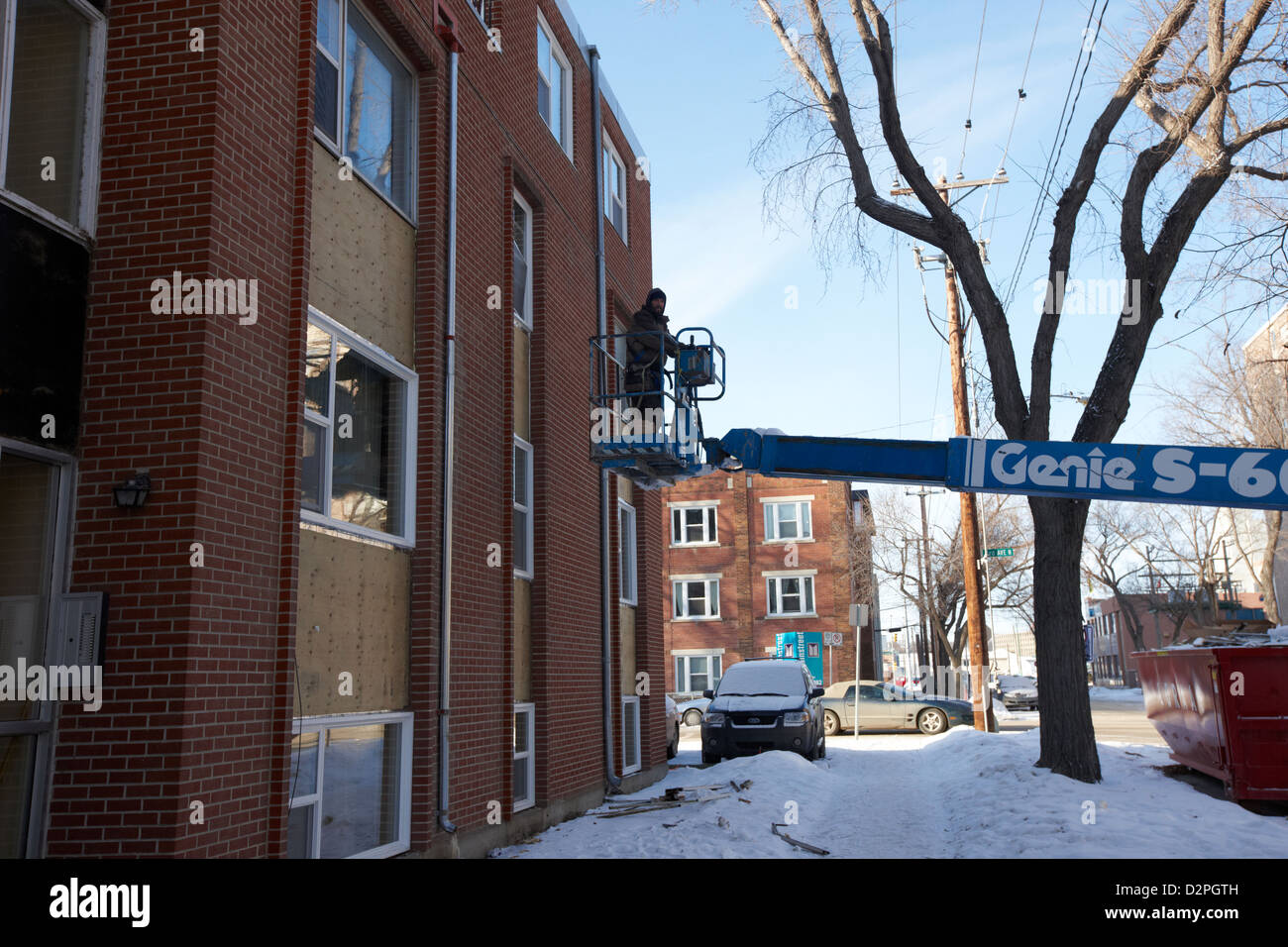 Mann auf Hubarbeitsbühne Arbeitsbühne arbeitet am Aufbau in Sub Minustemperaturen Saskatoon Saskatchewan Kanada Stockfoto