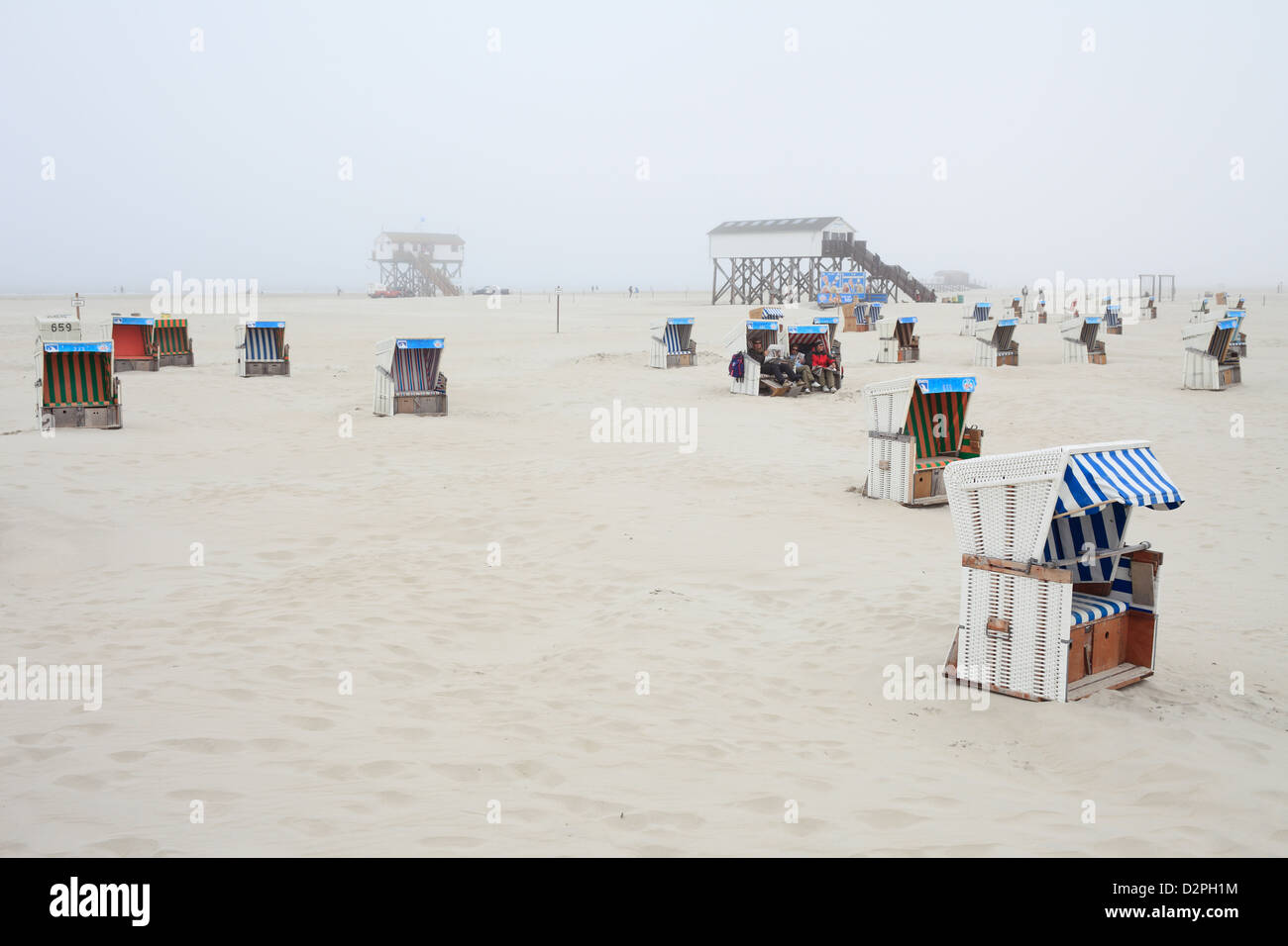 Sankt Peter-Ording, Deutschland, Strandkoerbe Stelzen im Nebel am Strand Stockfoto