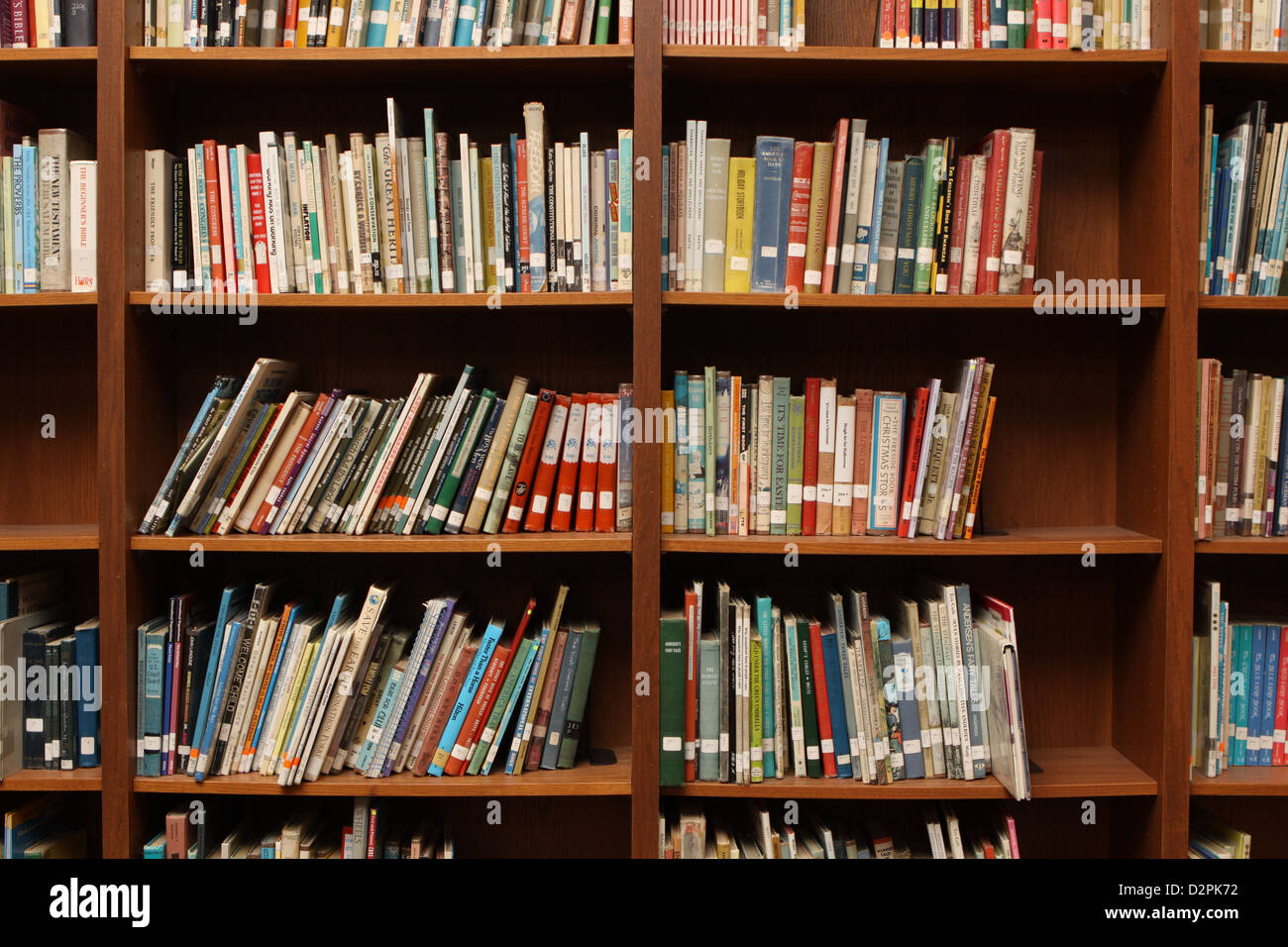 Eine Sammlung von Büchern auf einem Regal in eine Schulbibliothek mit Stacheln aus, Etiketten und nach Themen sortiert. Stockfoto