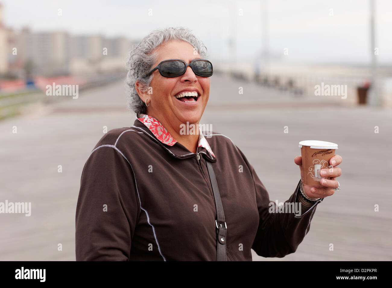 Lächelnde Frau Kaffee trinken auf Promenade Stockfoto