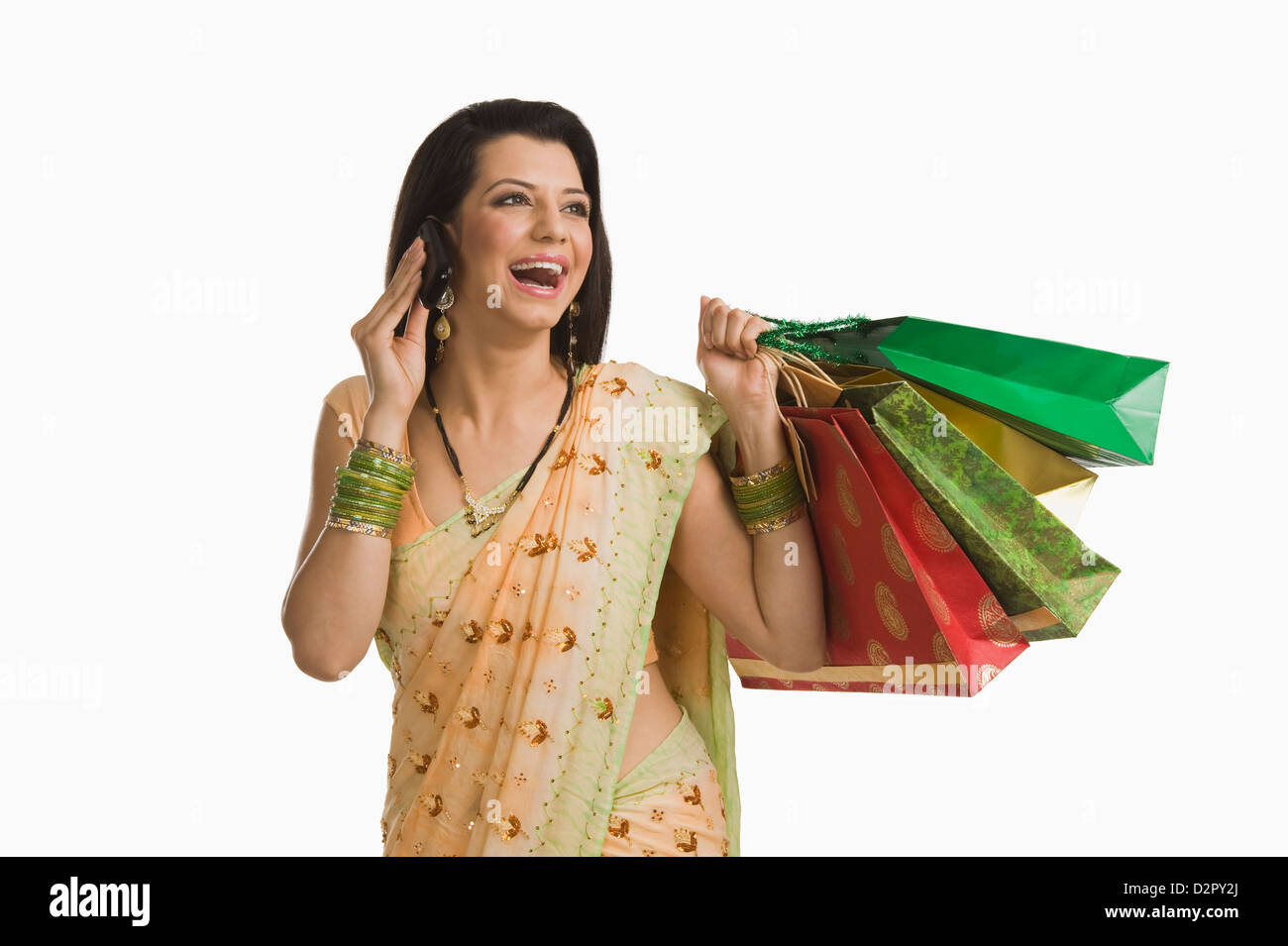 Frau telefonieren mit einem Handy und halten Einkaufstaschen Stockfoto