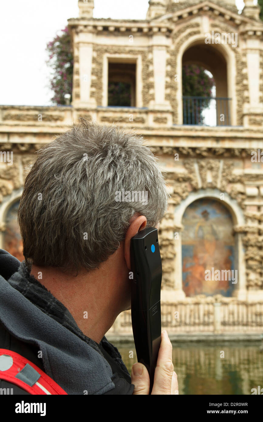 Mann mit Audiogerät hören eine audio Tour in Sevilla, Spanien Stockfoto