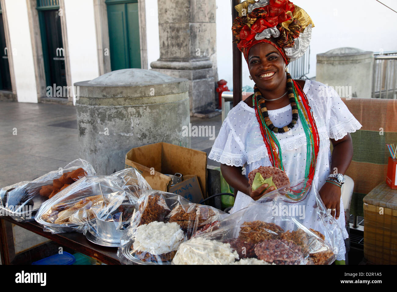 Bahianischen Frau im traditionellen weißen Kleid verkaufen Straße Essen im Stadtteil Pelourinho, Salvador, Bahia, Brasilien Stockfoto