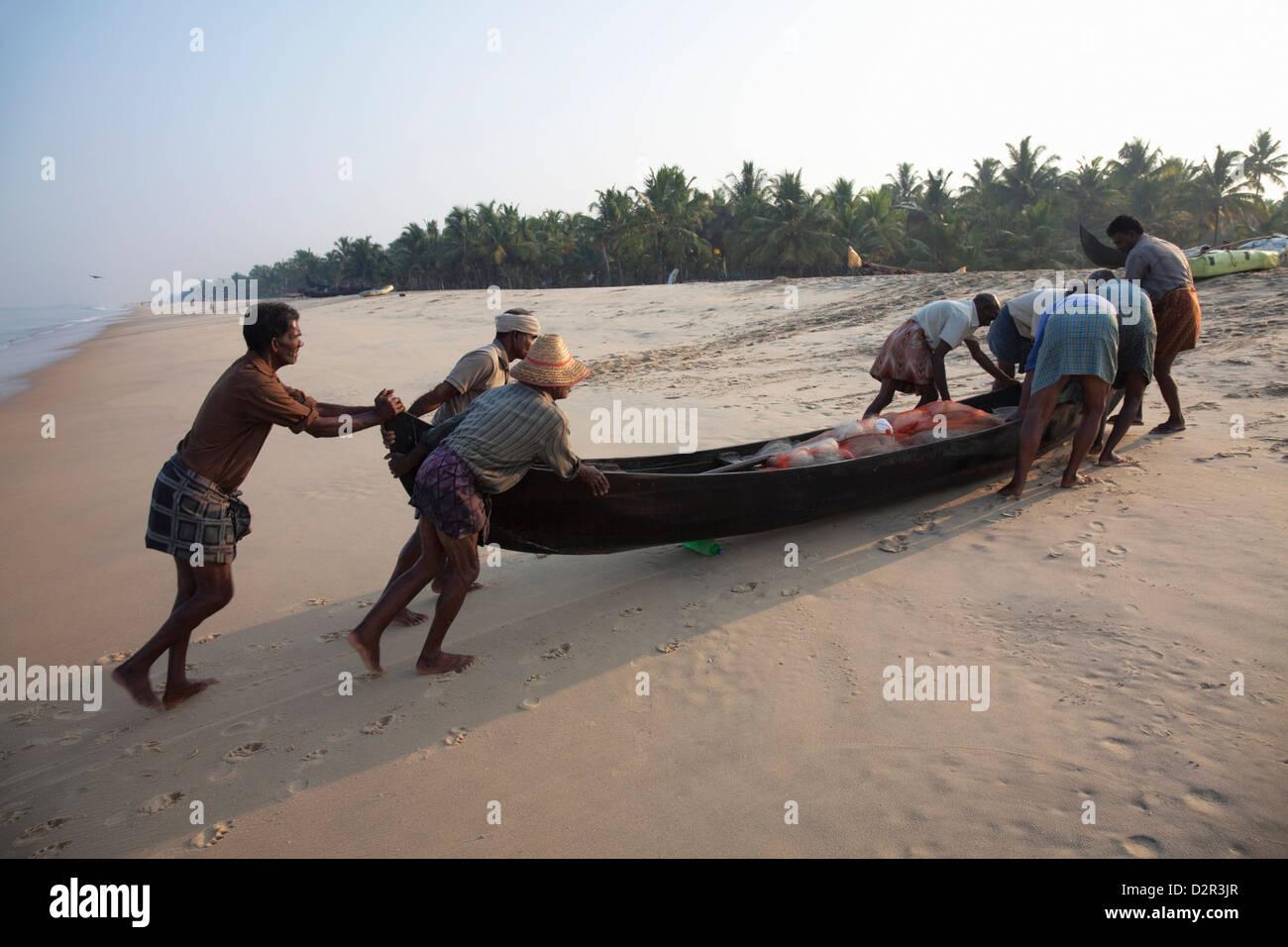 Fischer am Strand bei Marari Beach, Kerala, Indien, Asien traditionelles Boot mit Fang hochdrücken Stockfoto