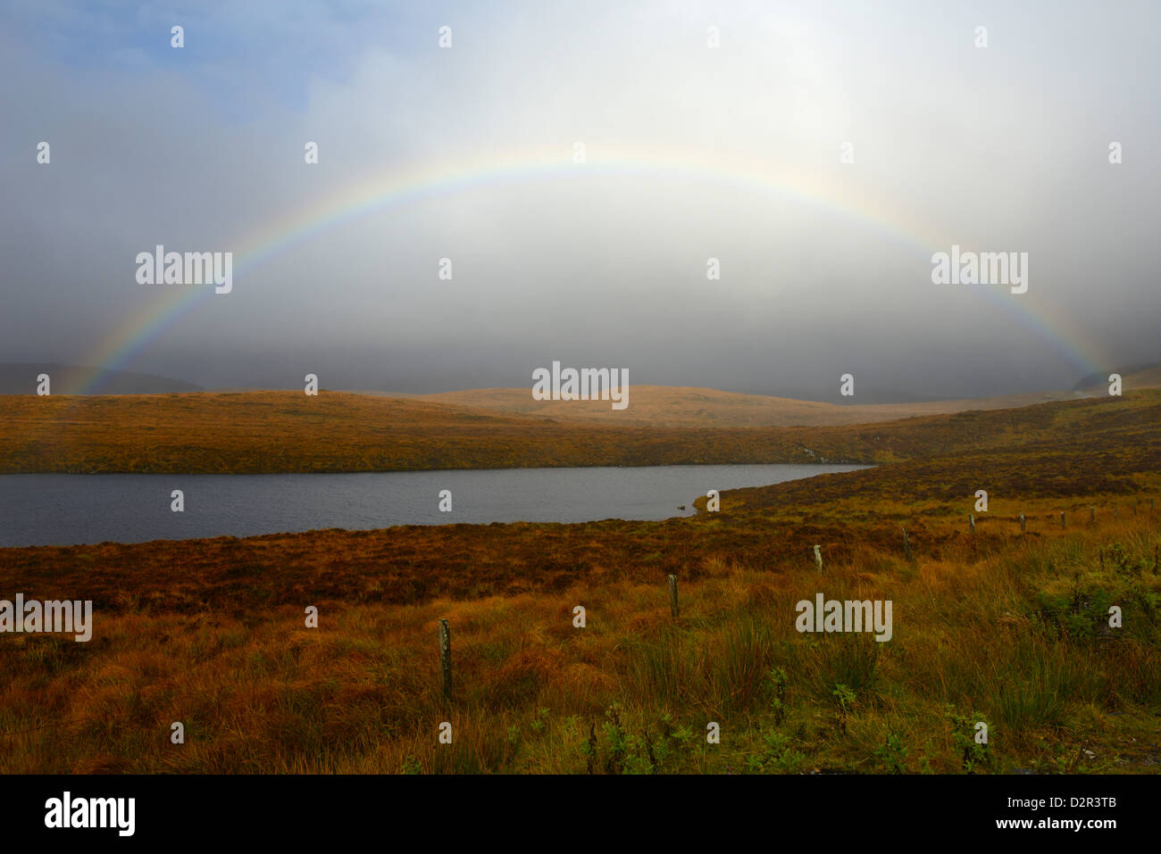 Gewitterhimmel und Regenbogen über ein Loch, Highlands, Schottland, Vereinigtes Königreich, Europa Stockfoto