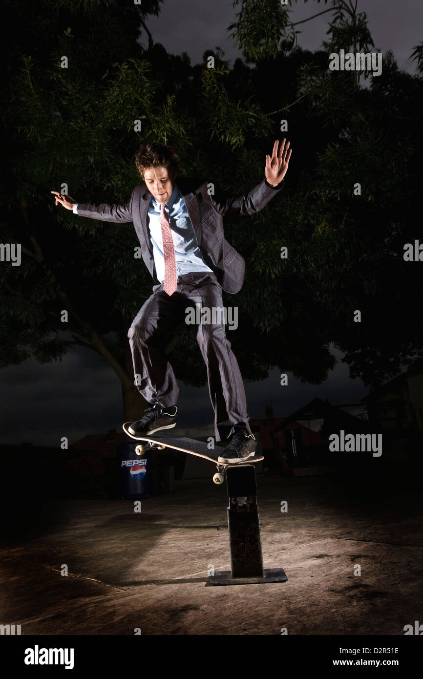 Mann im Anzug skateboarding in der Nacht Stockfoto