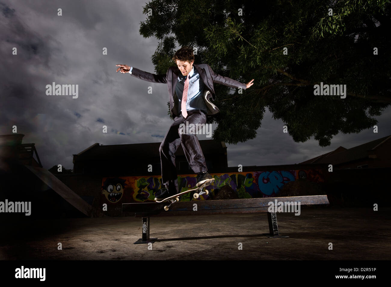 Mann im Anzug skateboarding in der Nacht Stockfoto