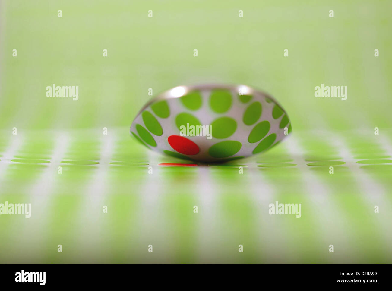 Tee-Löffel mit grünen Punkten und ein roter Punkt im Fokus Stockfoto