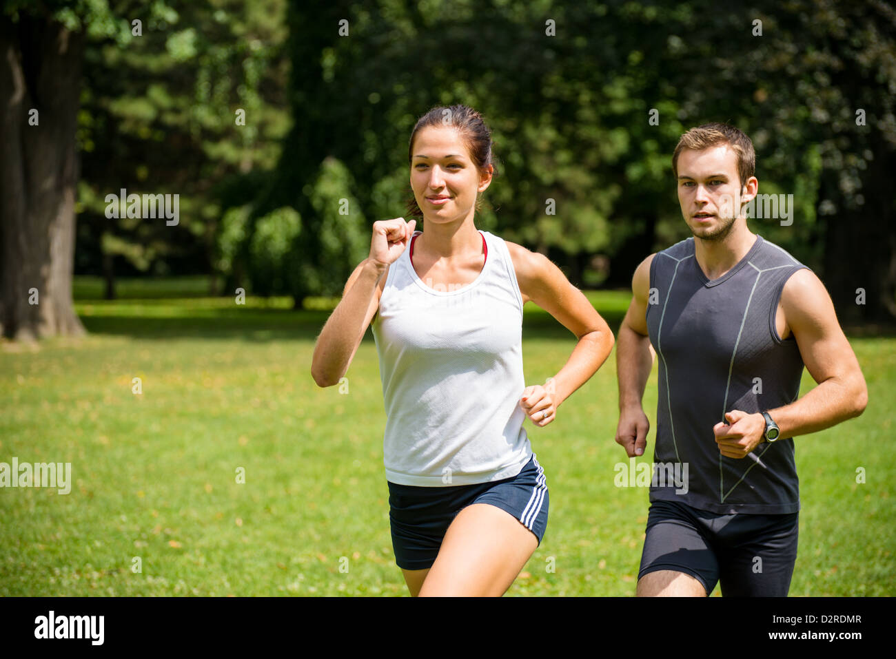 Paar jogging - junger Mann und Frau im Wettbewerb, Frau zuerst Stockfoto