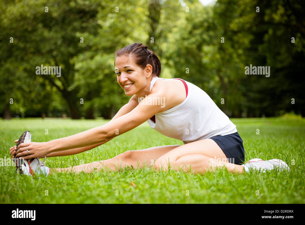 Junge Fitness Frau dehnen Sie Muskeln vor sportlichen Aktivitäten - outdoor im park Stockfoto