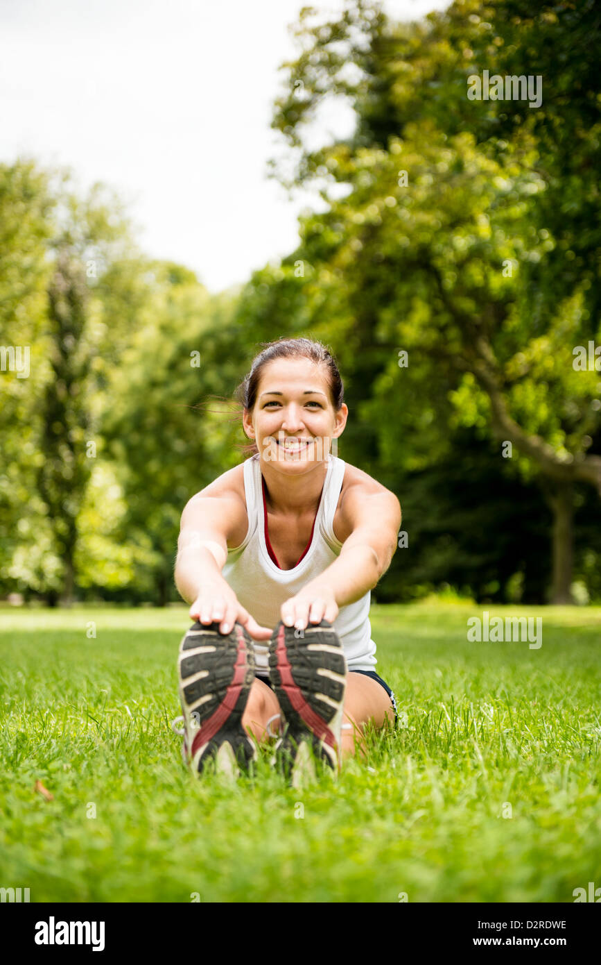 Junge Fitness Frau dehnen Sie Muskeln vor sportlichen Aktivitäten - outdoor im park Stockfoto