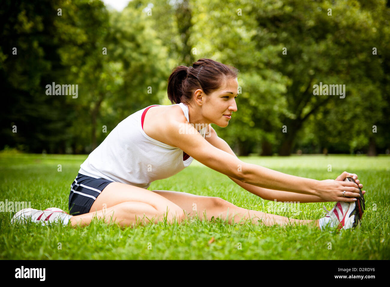 Junge Fitness Frau dehnen Sie Muskeln vor sportlichen Aktivitäten - Höhenplan Stockfoto