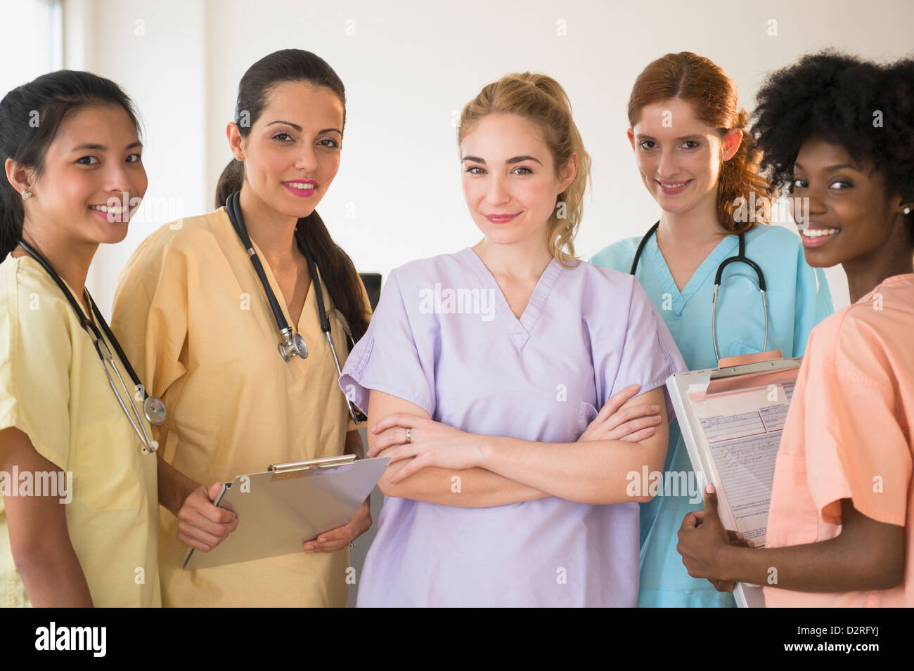 Krankenschwestern in bunten Peelings im Krankenhaus sprechen Stockfoto