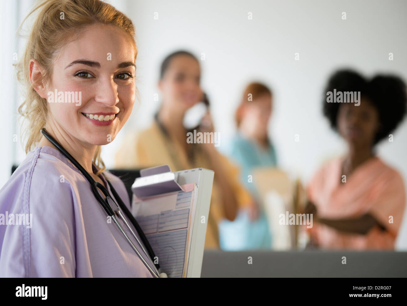 Lächelnd hält Zwischenablage im Krankenhaus Krankenschwester Stockfoto