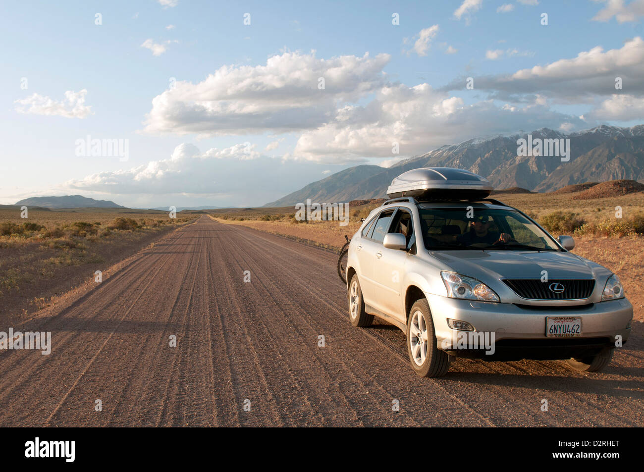 4WD Auto fährt auf einer unbefestigten Straße auf einem Roadtrip durch Owens Valley, Kalifornien in der Nähe von Bischof auf dem Weg zum Red Canyon bei Sonnenuntergang. Stockfoto