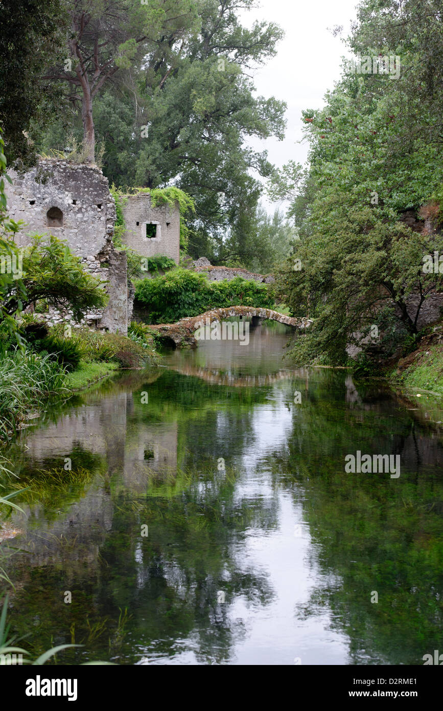 Blick entlang der romantischen Fluss und den Ponte Romano (Römerbrücke. Garten von Ninfa. Lazio Rom. Italien. Stockfoto