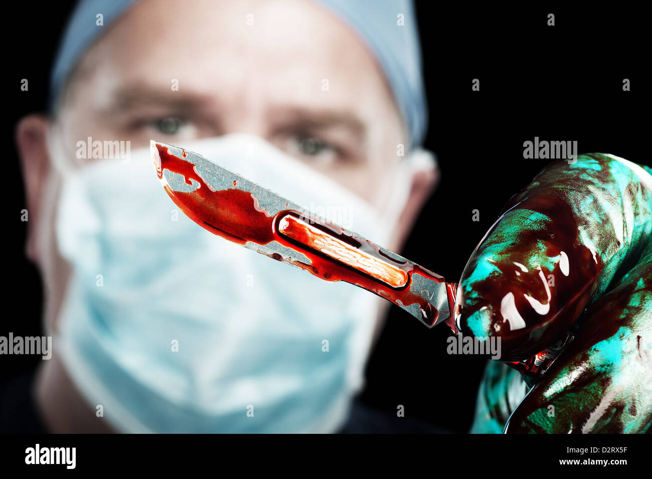Ein männlicher Chirurg hält eine scharfe, blutiges Skalpell während der Operation Stockfoto