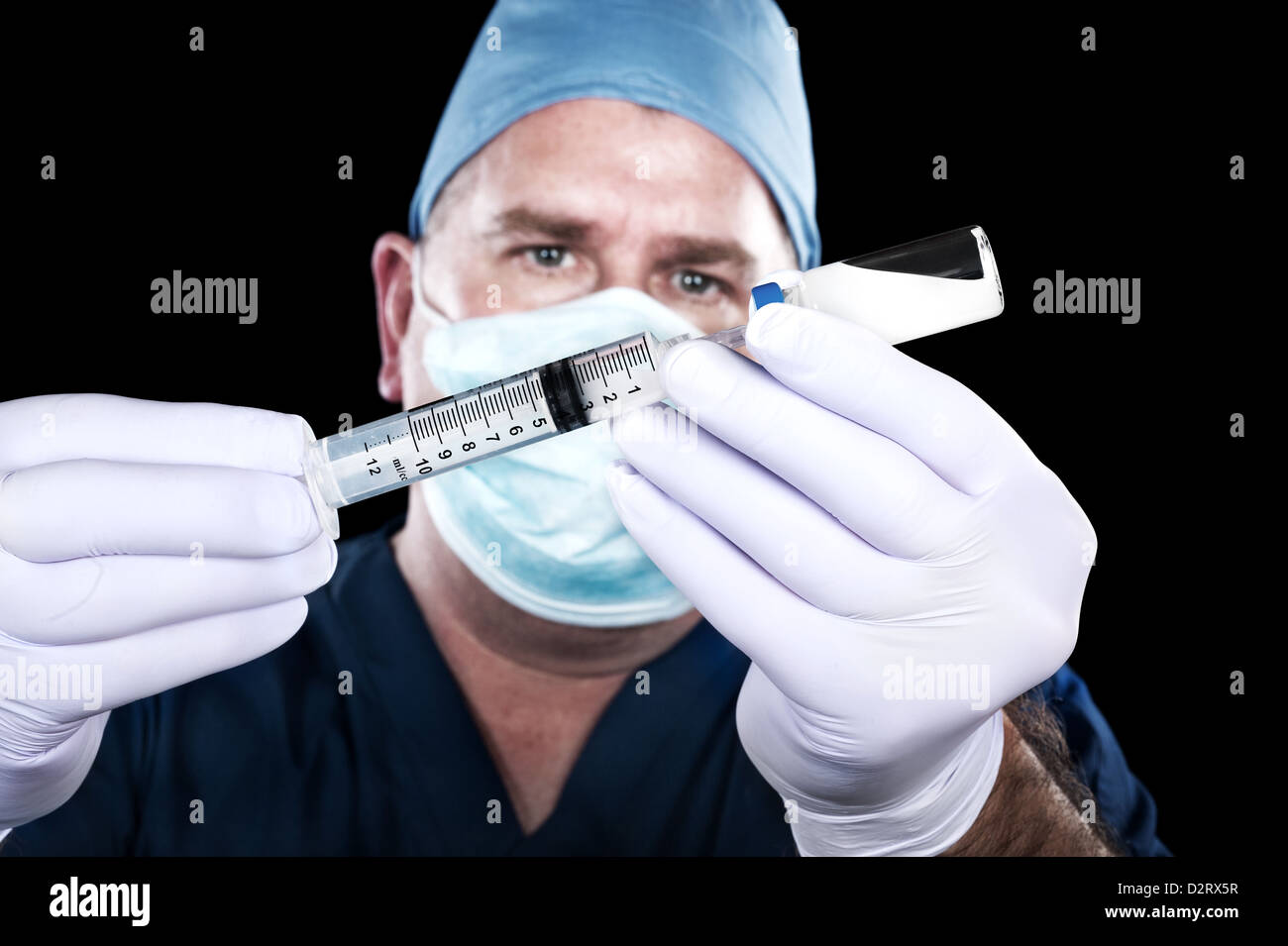 Ein Arzt entzieht Drogen ein Fläschchen in Vorbereitung ein Patienten zu injizieren. Stockfoto