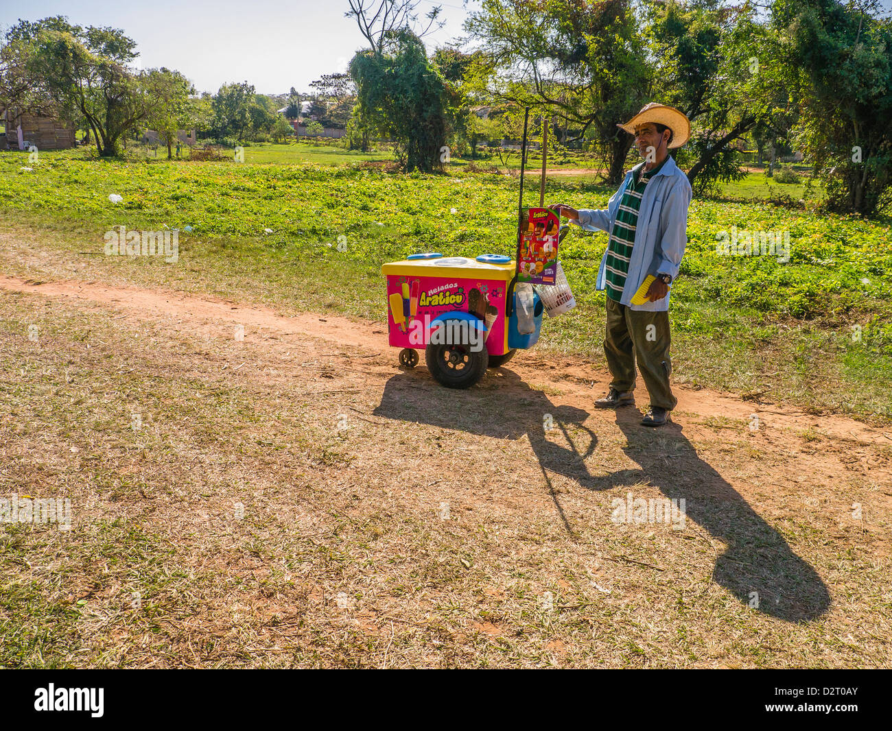 Eine männliche Hispanic Eisverkäufer steht mit seinem mobilen Eiswagen rollt er rund um das Dorf in einer ländlichen Gegend von Paraguay Stockfoto