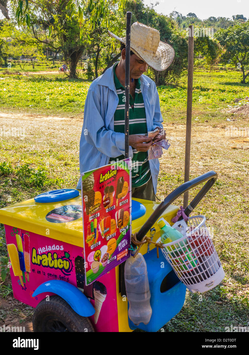 Eine männliche Hispanic Eisverkäufer steht mit seinem mobilen Eiswagen rollt er rund um das Dorf in einer ländlichen Gegend von Paraguay Stockfoto