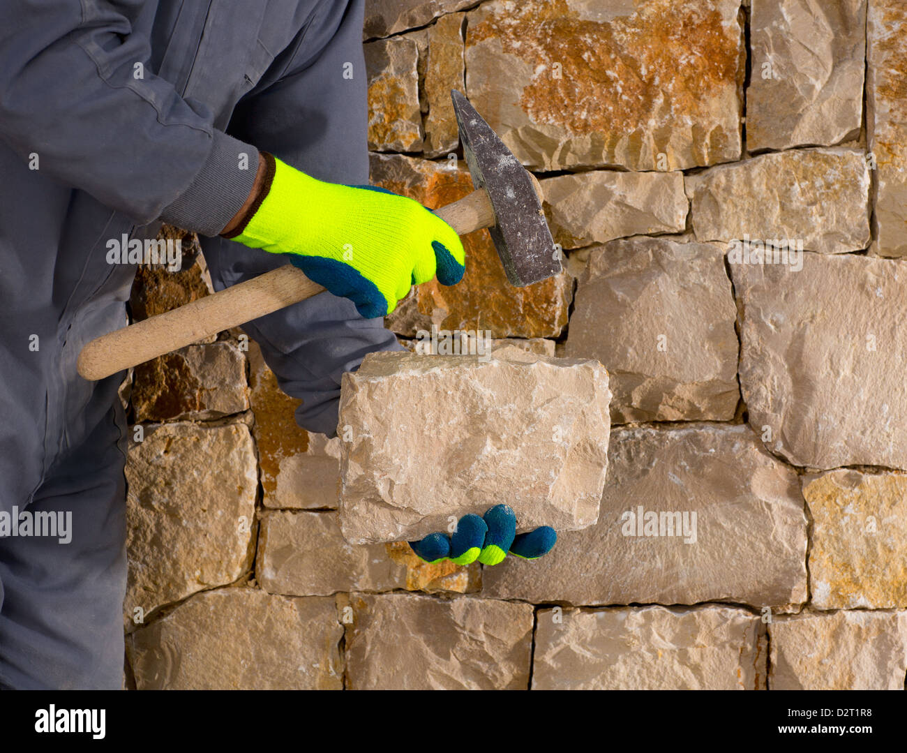 Steinmetz Mason mit Hammer und Gebäude einen Stein Mauerwerk aus Stein Stockfoto