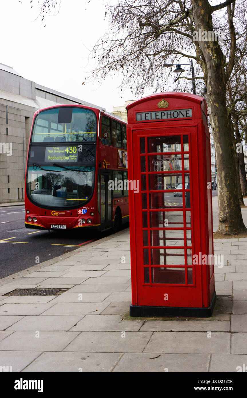 Eine typische K6 Modell London Telefonzelle vor der roten Volvo London Bus. Stockfoto