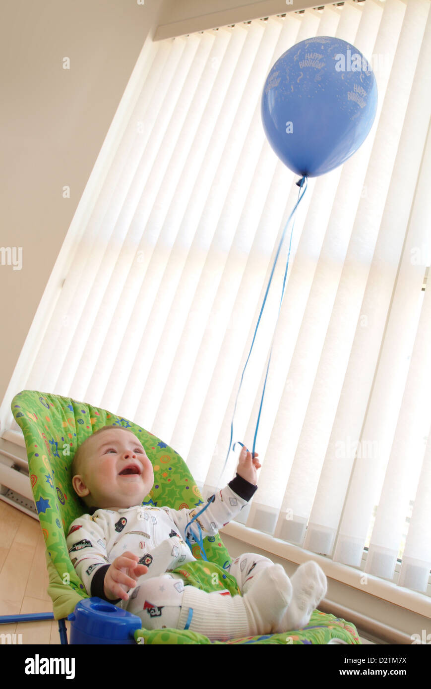 Baby mit einem blauen Ballon Stockfoto