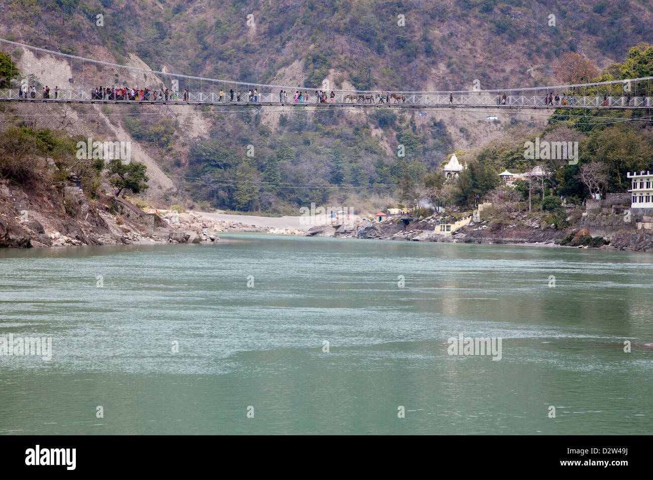 Indien, Rishikesh. Hängebrücke verbindet die beiden Ufer. Menschen und Maultiere überqueren. Stockfoto