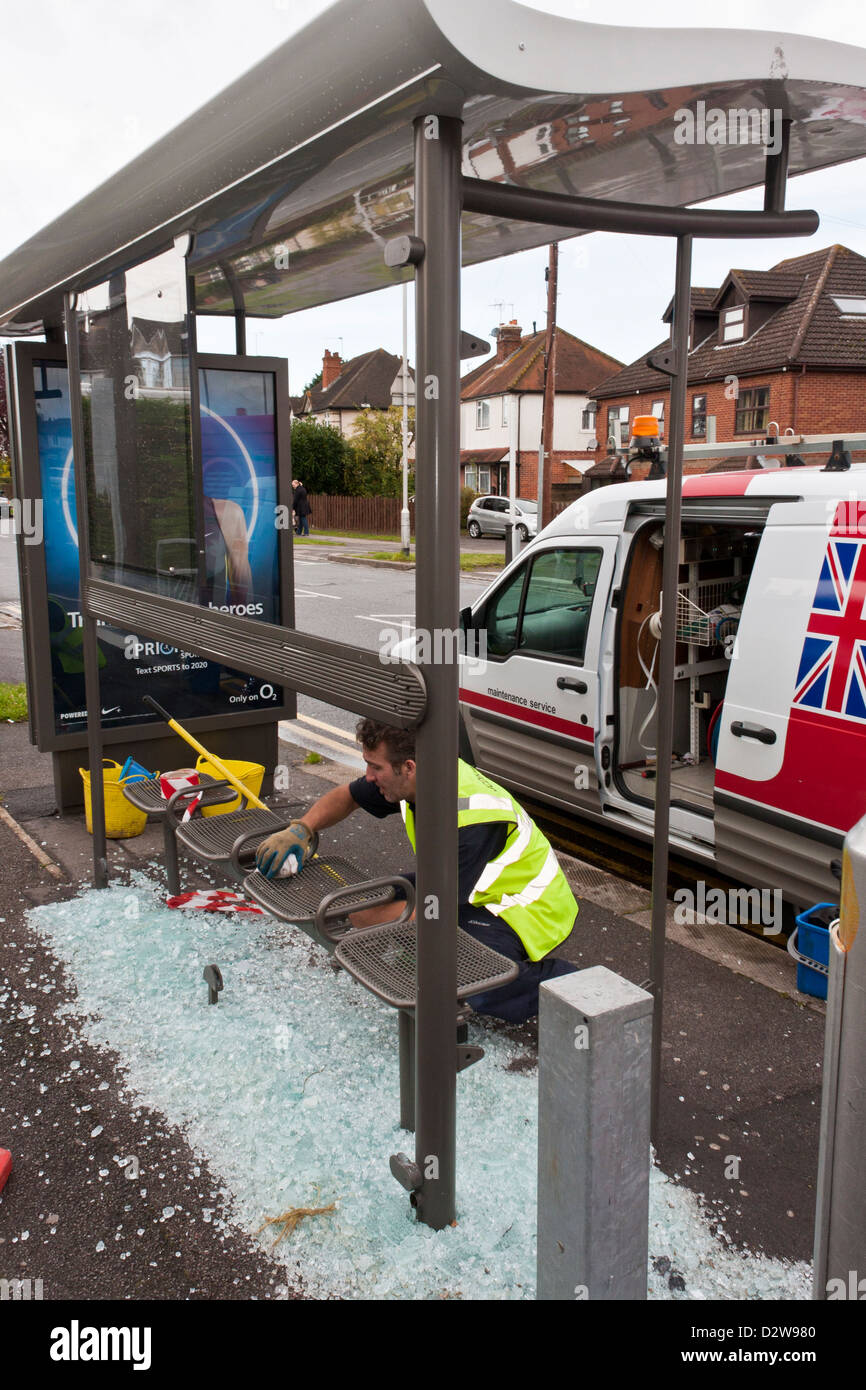 Arbeiter ersetzt Glasscherben in einem Tierheim geschändeter Bus. Stockfoto