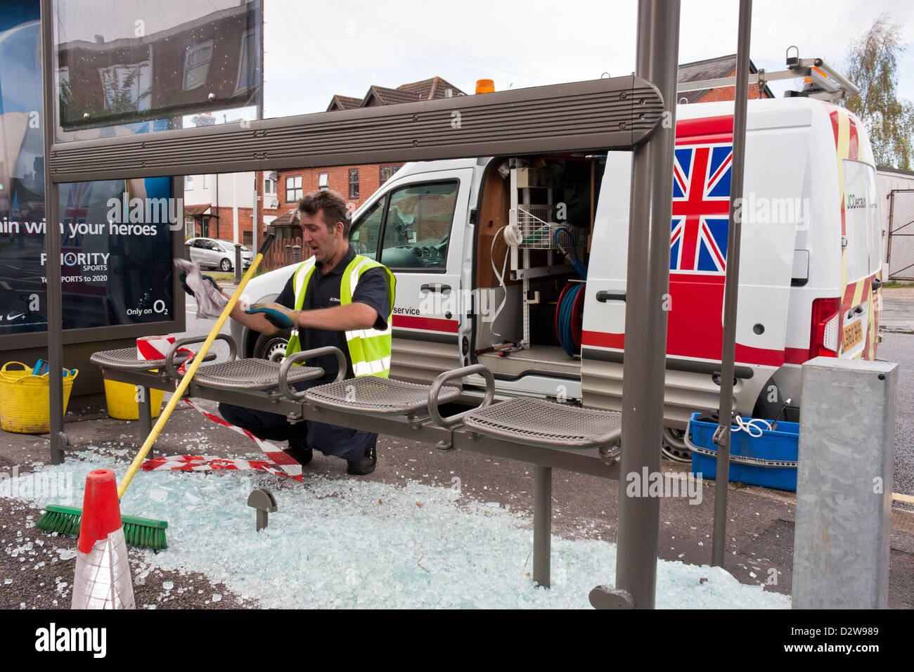 Arbeiter ersetzt Glasscherben in einem Tierheim geschändeter Bus. Stockfoto