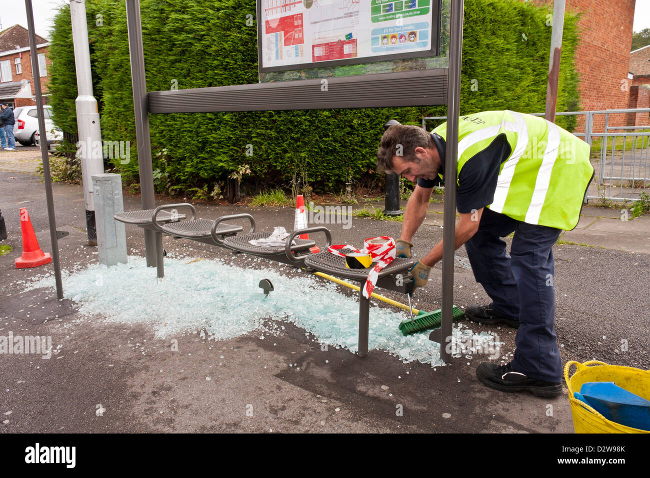 Arbeiter ersetzt Glasscherben in einem Tierheim geschändeter Bus. Stockfoto