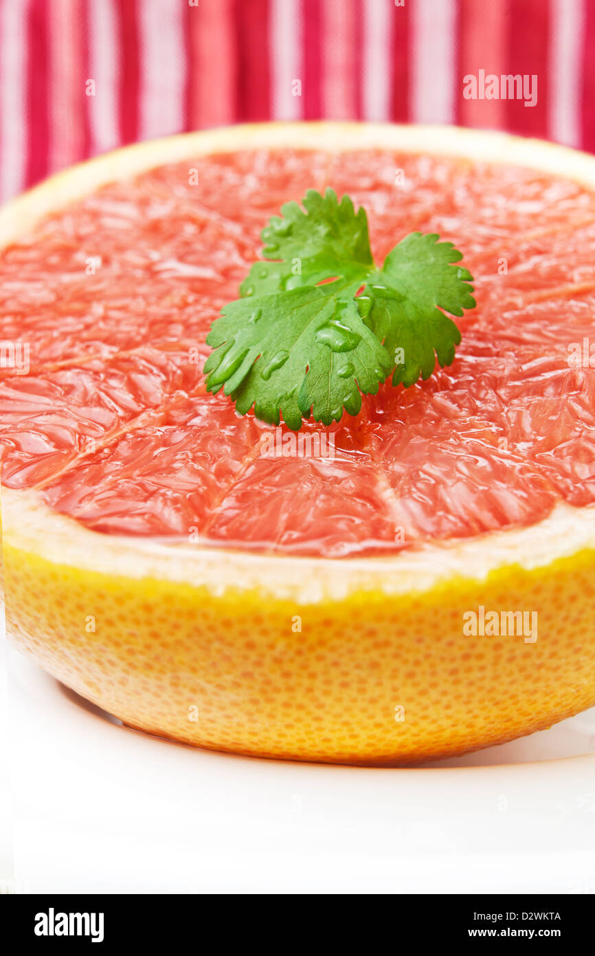 Halbe rosa Grapefruit frisch mit Korianderblätter geschnitten. Stockfoto